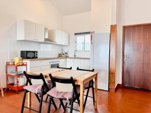 a kitchen with a wooden table and chairs at Casa do Profeta in Porto Santo