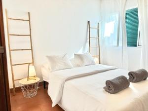 a bedroom with two beds with towels on them at Casa do Profeta in Porto Santo