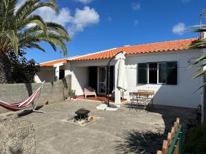 a house with a patio with a table and a hammock at Casa do Profeta in Porto Santo