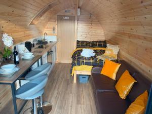 ein Zimmer mit Sofa und Tisch in einem winzigen Haus in der Unterkunft The Sandy Pod in Stornoway