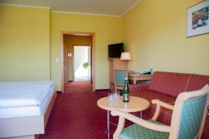 ein Hotelzimmer mit einem Bett, einem Sofa und einem Tisch in der Unterkunft GASTHOF SCHEER Feriendomizil in Bad Gleichenberg