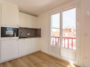 een keuken met witte kasten en een groot raam bij Appartement Saint-Jean-de-Luz, 2 pièces, 4 personnes - FR-1-4-566 in Saint-Jean-de-Luz