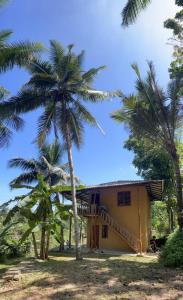 uma casa com palmeiras em frente em Morakanda Eco Villa em Elpitiya