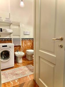 a bathroom with a toilet and a washer and dryer at Casa Melina - Venezia in Venice