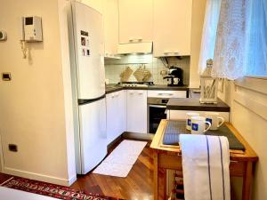a kitchen with a table and a white refrigerator at Casa Melina - Venezia in Venice
