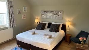 a bedroom with a large bed with two pillows at B&B Latemberg in Sint-Maria-Latem