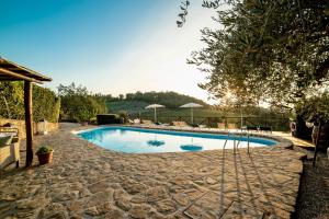 - une piscine entourée d'une passerelle en pierre dans l'établissement Podere Vergianoni immerso nelChianti con piscina, à Tavarnelle in Val di Pesa