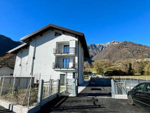 a white building with a balcony and a fence at Appartamento Due Laghi in Tenno