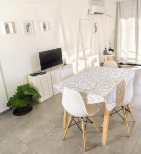 een eetkamer met een tafel en witte stoelen bij Hermoso espacio en Temperley in Temperley