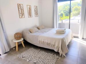 a white bedroom with a bed and a window at Hermoso depto en Temperley con cochera in Temperley