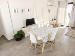 una sala da pranzo con tavolo e sedie bianche di Hermoso espacio en Temperley a Temperley