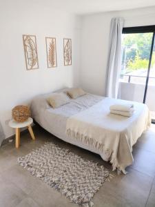 een witte slaapkamer met een bed en een raam bij Hermoso espacio en Temperley in Temperley