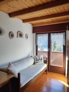 sala de estar con sofá y puerta de madera en Falcade Dolomiti La Quiete Mansarda panoramica, en Fregona