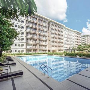 een groot appartementencomplex met een groot zwembad bij Daily Relax @ Trees Residence QC in Manilla