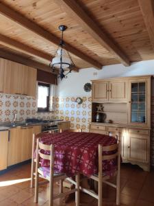 Falcade Dolomiti La Quiete Mansarda panoramica في Fregona: مطبخ مع طاولة وخزانة خشبية