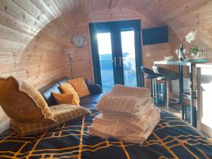 a room with a couch and a table and a clock at The Sandy Pod in Stornoway