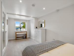 a bedroom with a bed and a desk and a window at Cleggan Pierside Apt 2 in Cleggan