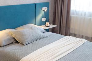 a bedroom with a bed with a blue head board at Аппартаменты Металлист посуточно VIP in Kharkiv