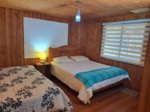 um quarto com duas camas e uma janela. em HOSTAL CARHUELLO em Pucón