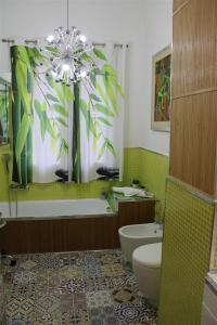 uma casa de banho com uma banheira, um WC e um lavatório. em Green House Apartment al Massimo em Palermo