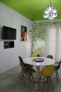 uma sala de jantar com uma mesa branca e cadeiras em Green House Apartment al Massimo em Palermo