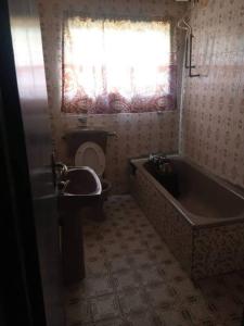 a bathroom with a tub and a toilet and a window at ClinClia Hotel2 in Ibadan
