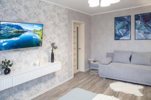 a living room with a couch and a tv on the wall at Аппартаменты Металлист посуточно VIP in Kharkiv