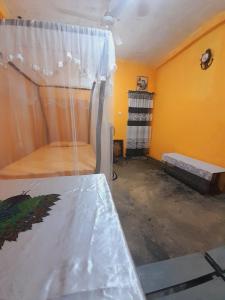 坦加拉的住宿－Milton Home Stay，一间黄色墙壁的房间,配有一张床铺