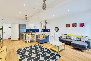 a living room with a couch and a kitchen at Gem on the Rye in London