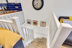 Un escalier blanc avec une horloge sur le mur dans l'établissement Gem on the Rye, à Londres