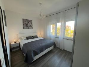 Un dormitorio con una cama grande y una ventana en Guesthouse Villa Stanger 2 en Lovran