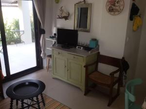 a living room with a desk with a television and a chair at Maya's House at Sani in Sani Beach