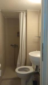 a bathroom with a toilet and a sink at Maya's House at Sani in Sani Beach +25 photos