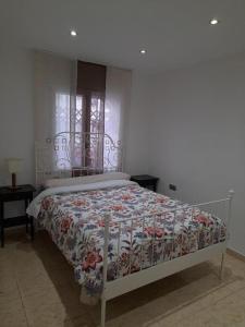 SWEET HOUSE CLOSE TO AIRPORT في برشلونة: غرفة نوم مع سرير مع لحاف متهالك