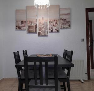 una mesa de comedor negra con sillas y una lámpara de araña en SWEET HOUSE CLOSE TO AIRPORT en Barcelona