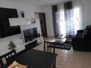 uma sala de estar com um sofá e uma televisão em SWEET HOUSE CLOSE TO AIRPORT em Barcelona