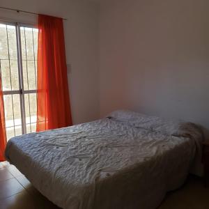 a bed in a bedroom next to a window at Dpto cercano al centro con WIFI in San Luis