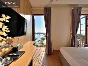 a bedroom with a bed and a tv and a balcony at HANZ LAGOON SUNSET ITALIANO BOUTIQUE in Phu Quoc