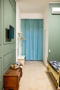 Zimmer mit einem Bett, einem Tisch und einem blauen Vorhang in der Unterkunft Bologna Travel Suite in Bologna