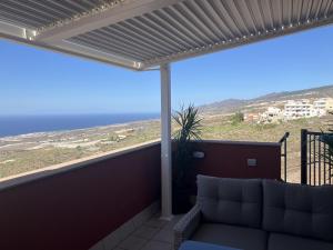 a balcony with a couch and a view of the ocean at Narancsvirág in Tejina de Isora
