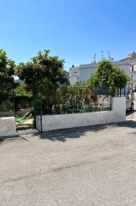 una cerca blanca con una puerta en un estacionamiento en Wine & Roses, en Mattinata