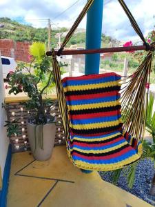 a hammock chair on a porch with a plant at Caridade Loft in Monte das Gameleiras