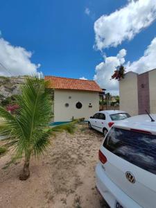 a car parked in front of a house with a palm tree at Caridade Loft in Monte das Gameleiras