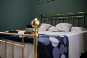 ein Bett mit einer blauen und weißen Decke und Kissen in der Unterkunft Bologna Travel Suite in Bologna