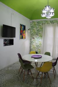 uma sala de jantar com mesa e cadeiras em Green House Apartment al Massimo em Palermo