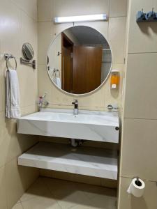 a bathroom with a white sink and a mirror at Reem 1 in Ajman 