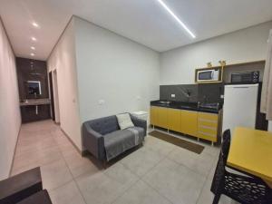 sala de estar con sofá y cocina en LOFT D Hospedagem Cidade Verde D, en Maringá