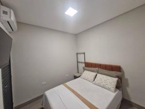 1 dormitorio con 1 cama en una habitación blanca en LOFT D Hospedagem Cidade Verde D, en Maringá