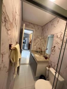 een badkamer met een toilet, een wastafel en een spiegel bij Beach Corais Alto Padrão in Santa Cruz Cabrália