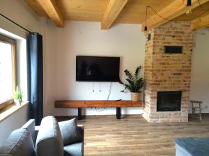 a living room with a fireplace and a flat screen tv at MaGórka in Krempna